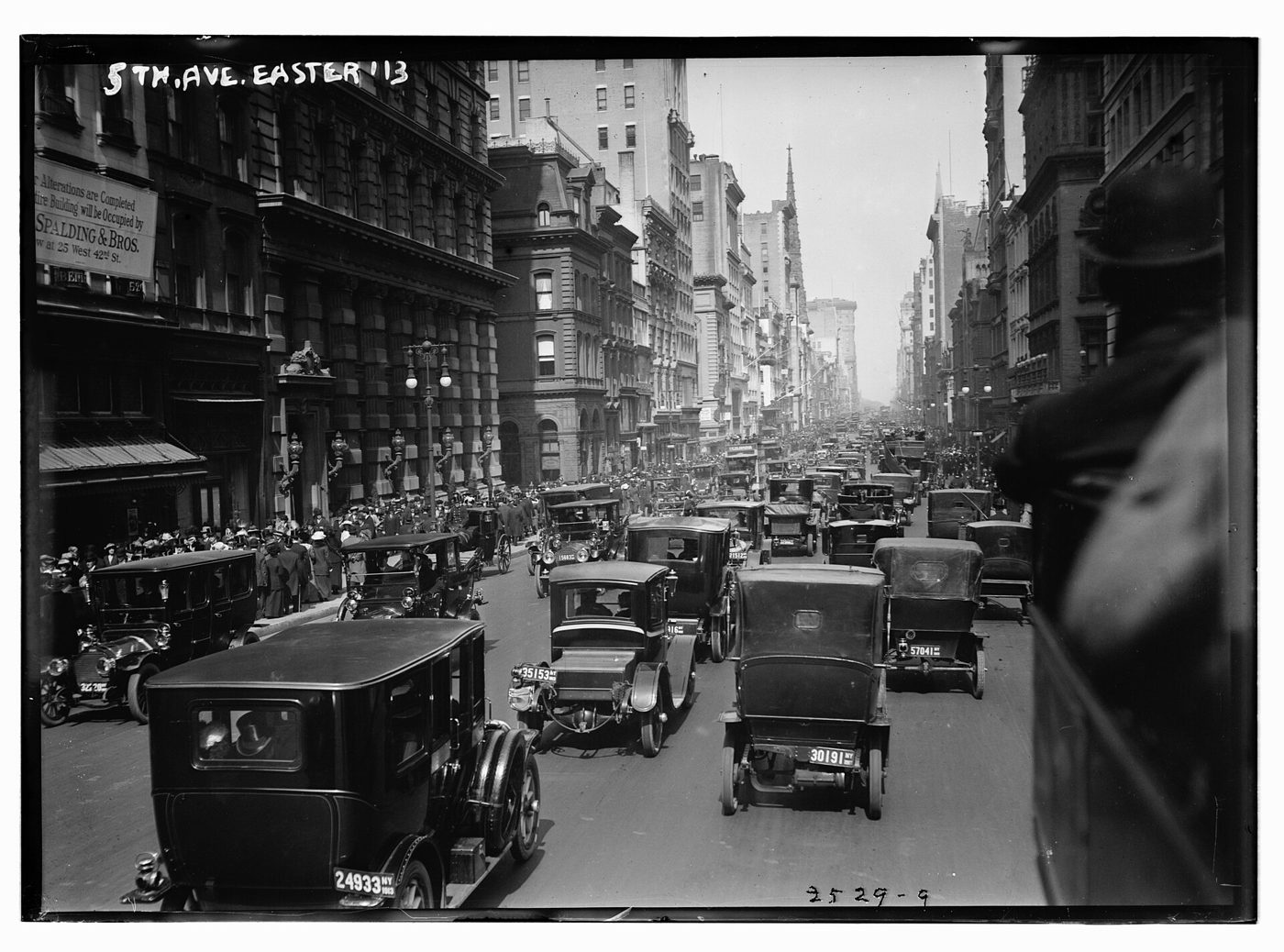 Black-and-white photo of Fifth Avenue, New York, at Easter 1913, filled with motor cars and taxis.
